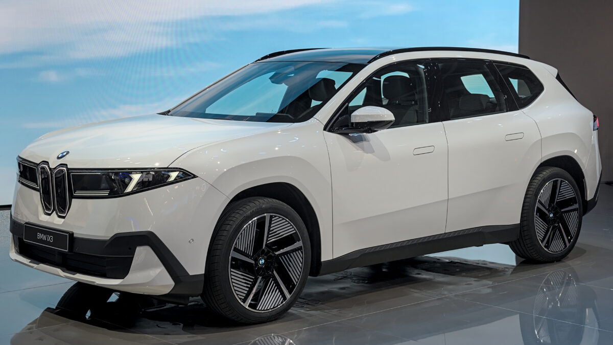 Biały BMW iX3 nowej generacji na stoisku targowym, widok z przodu i z boku