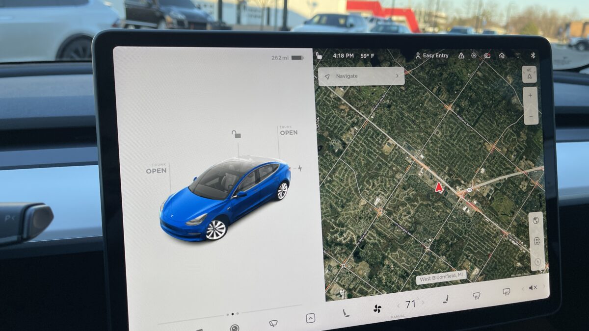 Duży ekran centralny w kabinie Tesli Model 3, widok z wnętrza