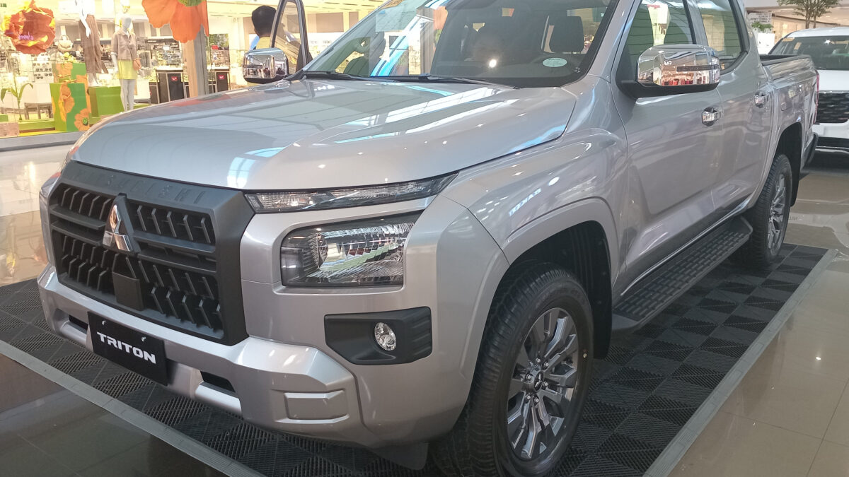 Srebrny Mitsubishi Triton obecnej generacji z podwójną kabiną w salonie, widok z przodu